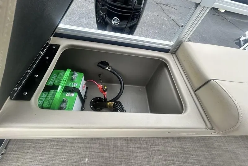 Slide: The Image of Battery compartment of 2021 Sun Tracker SportFish 22 DLX boat, featuring green batteries. - 11