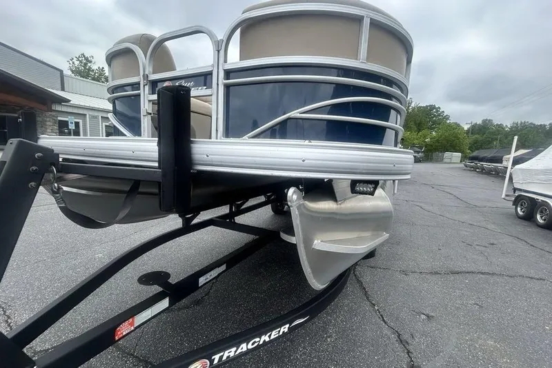 Slide: The Image of 2021 Sun Tracker SportFish 22 DLX pontoon boat on trailer, parked outdoors. - 13