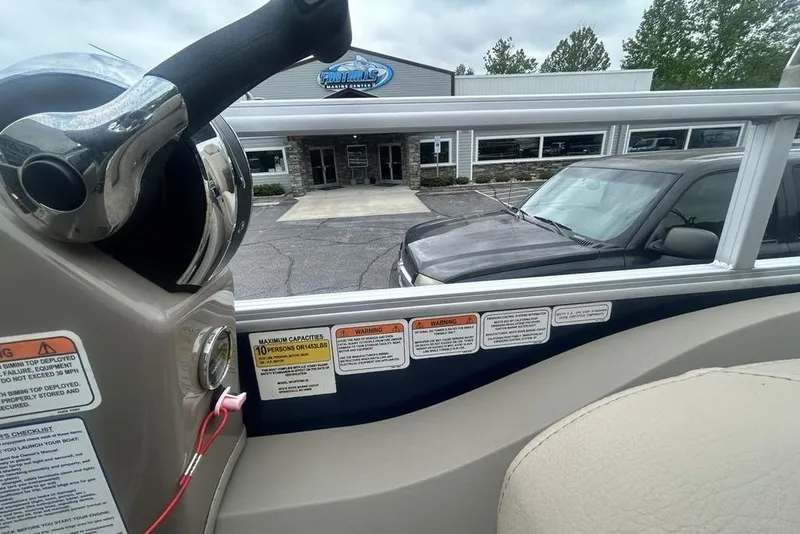 Slide: The Image of 2021 Sun Tracker SportFish 22 DLX boat dashboard with warning labels, parked outside dealership. - 19