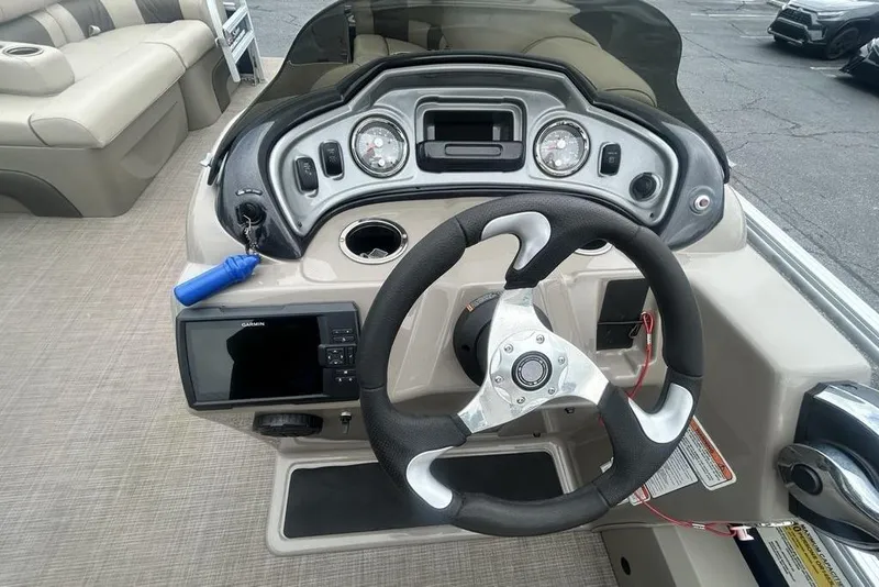 Slide: The Image of 2021 Sun Tracker SportFish 22 DLX boat dashboard with steering wheel and Garmin display. - 22