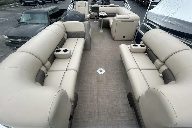Slide: The Image of 2021 Sun Tracker SportFish 22 DLX pontoon boat interior with beige seating and cup holders. - 3