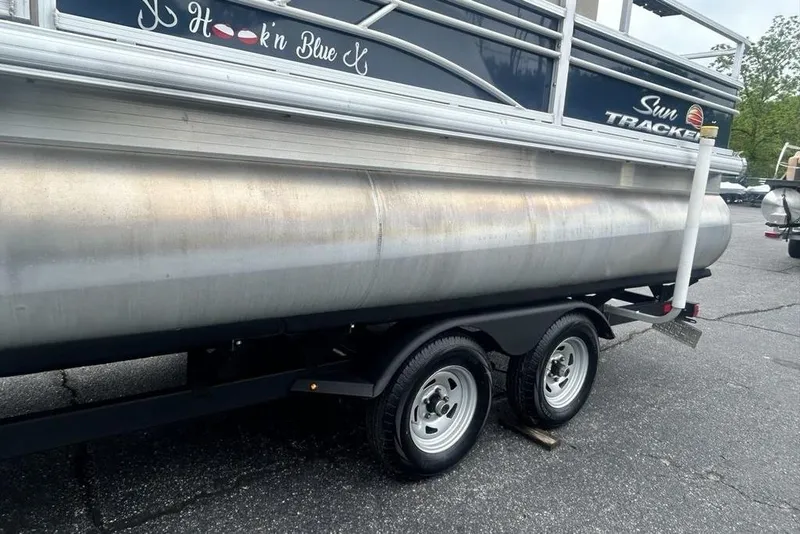 Slide: The Image of 2021 Sun Tracker SportFish 22 DLX pontoon boat on a trailer, side view. - 8