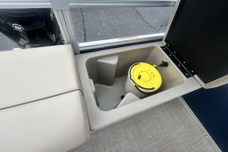 Slide: The Image of Sun Tracker SportFish 22 DLX 2021 boat storage compartment with yellow lid container. - 9