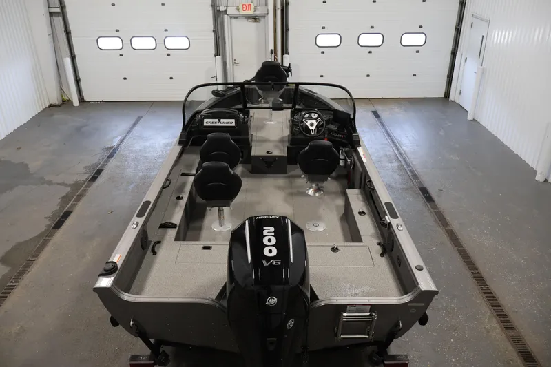 Slide: The Image of 2025 Crestliner 1950 Fish Hawk WT boat in a garage, featuring a powerful 200 V6 engine. - 10
