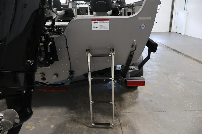Slide: The Image of 2025 Crestliner 1950 Fish Hawk WT boat with ladder and motor in a garage. - 37