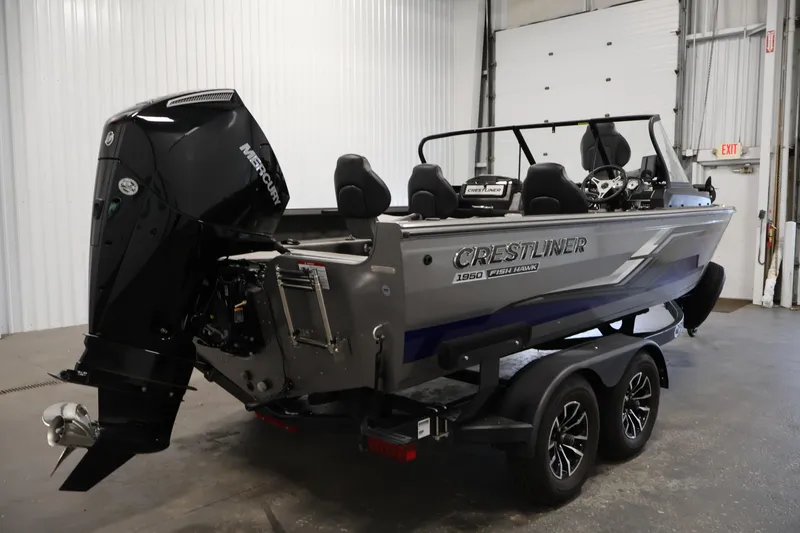 Slide: The Image of 2025 Crestliner 1950 Fish Hawk WT boat with Mercury engine in a garage setting. - 5