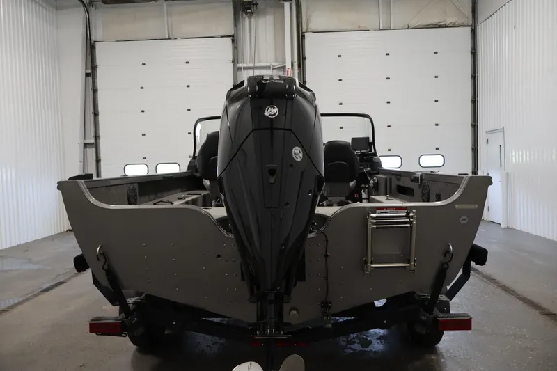 Slide: The Image of 2025 Crestliner 1950 Fish Hawk WT boat in a garage, rear view with motor. - 6