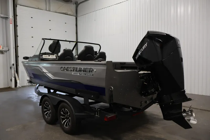 Slide: The Image of 2025 Crestliner 1950 Fish Hawk WT boat with Mercury outboard motor in a garage. - 7