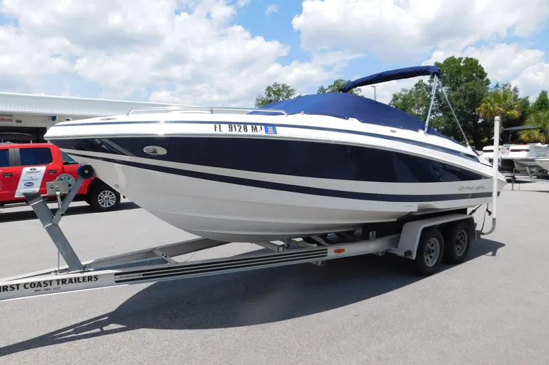 The Image of 2004 Regal 2250 LSC boat on trailer, blue and white design, parked outdoors. - 1