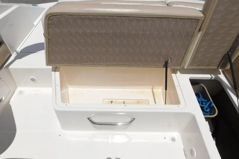 Slide: The Image of Open storage compartment on a 2004 Regal 2250 LSC boat, featuring beige upholstery. - 15