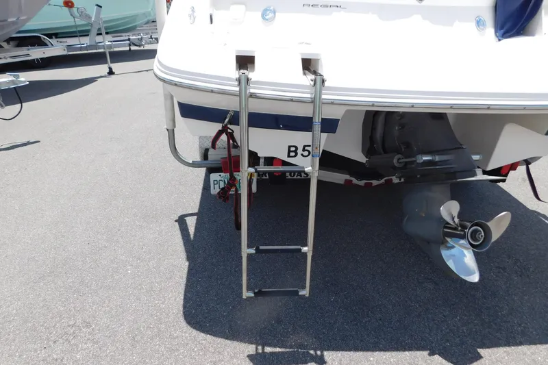 Slide: The Image of 2004 Regal 2250 LSC boat with ladder and propeller, parked on asphalt. - 9