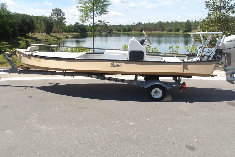 The Image of 2002 Gheenoe Classic 15 boat on trailer by a scenic lake. - 0