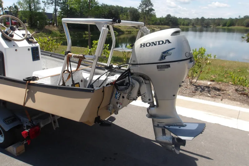 Slide: The Image of 2002 Gheenoe Classic 15 boat with Honda outboard motor by a scenic lake. - 6