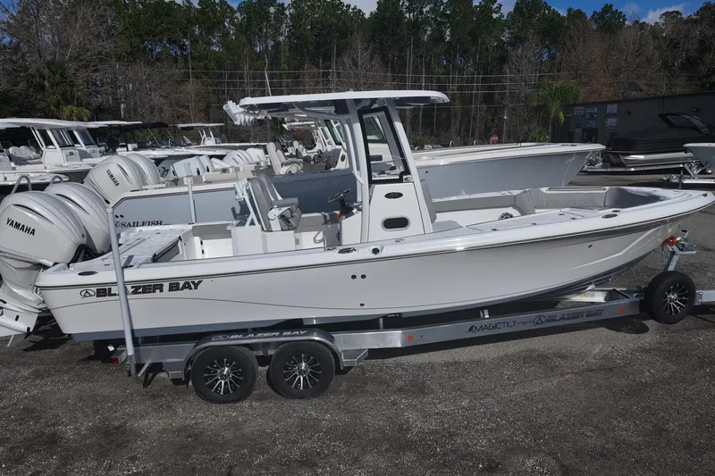 Slide: The Image of 2026 Blazer Bay Makaira 2800 boat on trailer, featuring Yamaha engines, parked outdoors. - 3