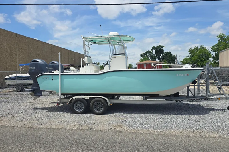 The Image of 2015 Tideline 235 boat on trailer with dual Yamaha engines, parked outdoors. - 0