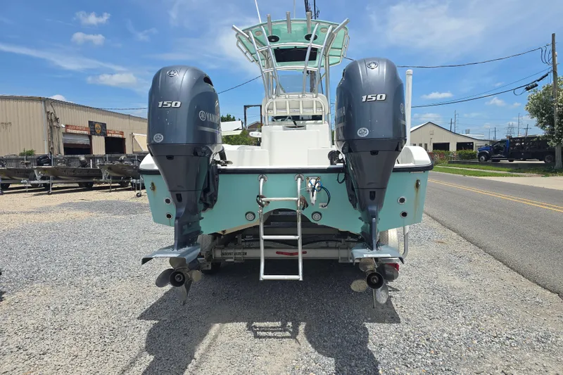Slide: The Image of 2015 Tideline 235 boat with dual Yamaha 150 outboard motors, parked on gravel. - 4
