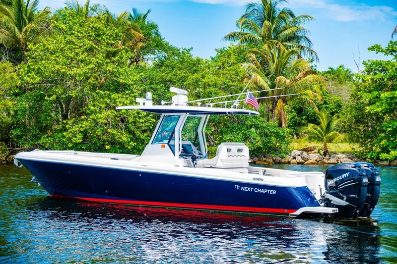 Slide: The Image of 2018 Intrepid 327 Center Console boat on water, surrounded by lush greenery. - 10