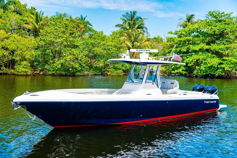 Slide: The Image of 2018 Intrepid 327 Center Console boat on a scenic waterway with lush greenery. - 13
