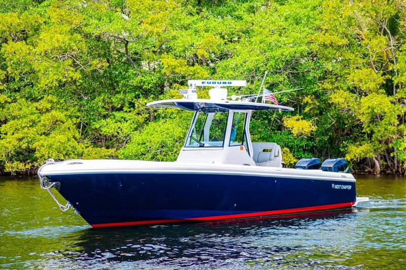 Slide: The Image of 2018 Intrepid 327 Center Console boat on water, surrounded by lush greenery. - 14