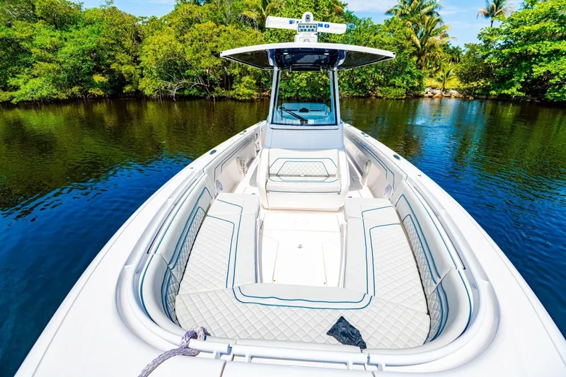 Slide: The Image of 2018 Intrepid 327 Center Console boat on serene water, surrounded by lush greenery. - 16