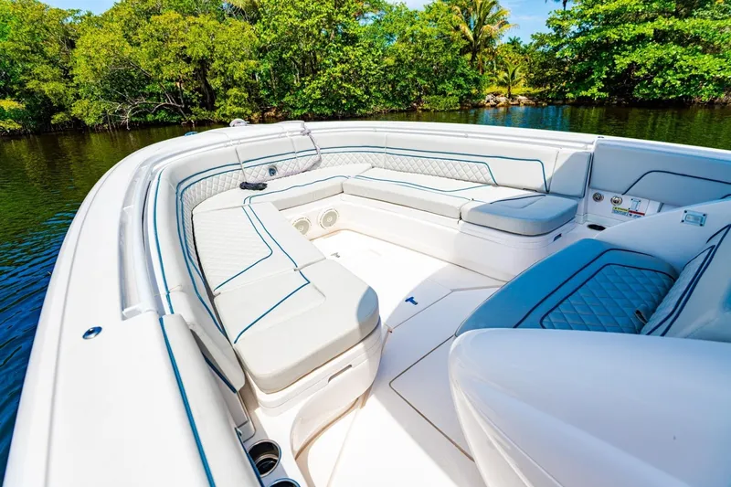 Slide: The Image of 2018 Intrepid 327 Center Console boat interior with luxurious seating and scenic water backdrop. - 19