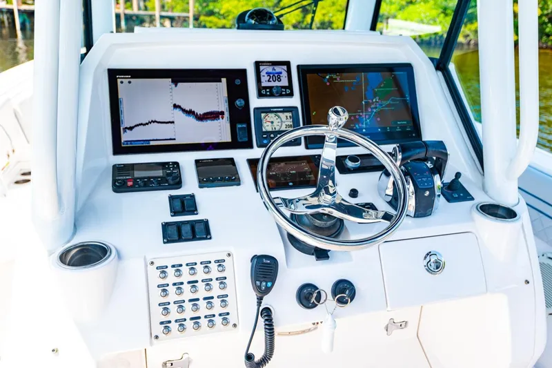 Slide: The Image of 2018 Intrepid 327 Center Console boat dashboard with navigation screens and controls. - 28