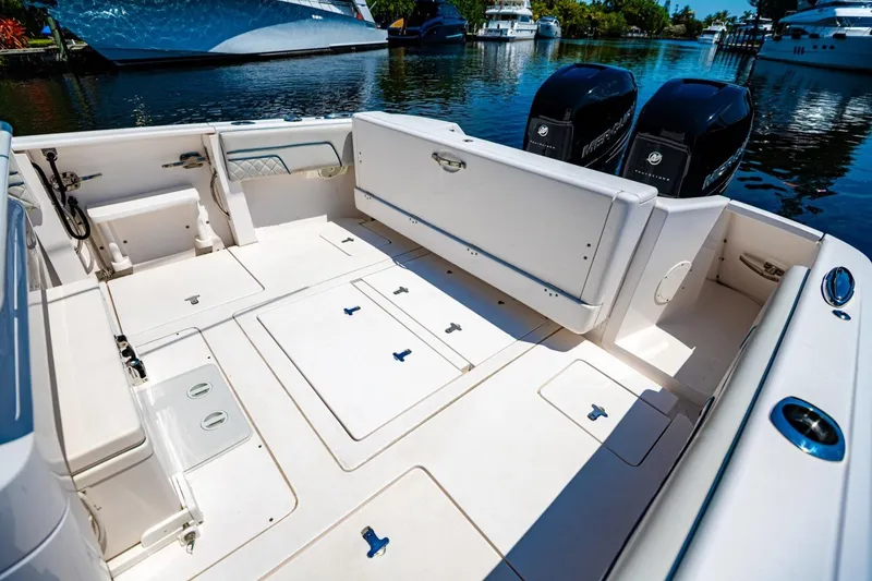Slide: The Image of 2018 Intrepid 327 Center Console boat interior with dual Mercury engines, docked on a sunny day. - 30