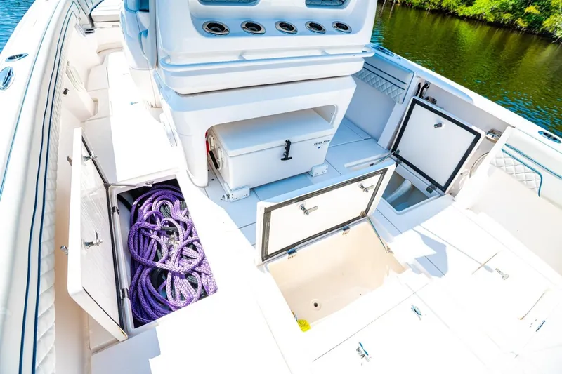 Slide: The Image of 2018 Intrepid 327 Center Console boat with open storage compartments and purple ropes. - 31
