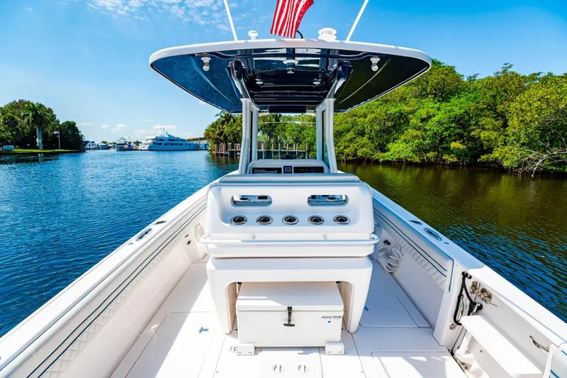 Slide: The Image of 2018 Intrepid 327 Center Console boat on a scenic waterway with lush greenery. - 34