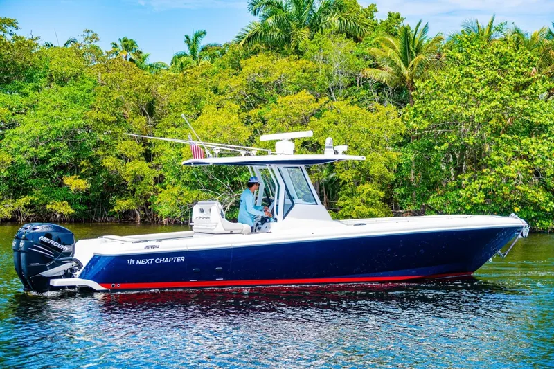 Slide: The Image of 2018 Intrepid 327 Center Console boat on water, surrounded by lush greenery. - 4