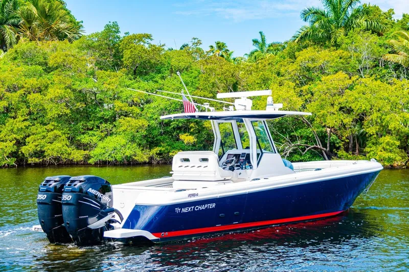 Slide: The Image of 2018 Intrepid 327 Center Console boat on water, surrounded by lush greenery. - 5