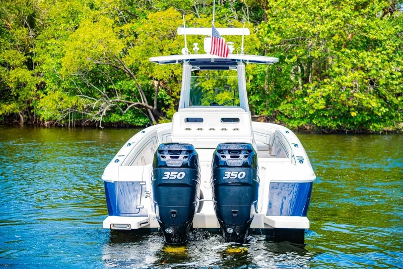 Slide: The Image of 2018 Intrepid 327 Center Console boat with twin 350 engines on a scenic waterway. - 6