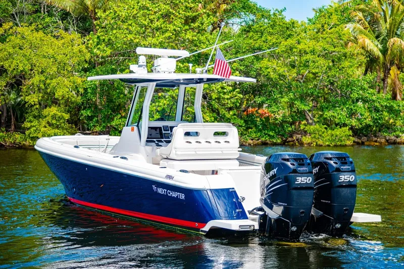 Slide: The Image of 2018 Intrepid 327 Center Console boat with dual Mercury engines on a scenic waterway. - 8