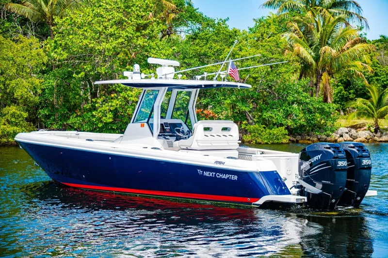 Slide: The Image of 2018 Intrepid 327 Center Console boat on water, surrounded by lush greenery. - 9