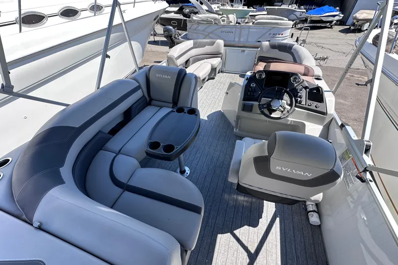 Slide: The Image of 2022 Sylvan L1 CRS pontoon boat interior with plush seating and modern helm. - 10