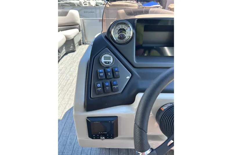 Slide: The Image of 2022 Sylvan L1 CRS boat dashboard with controls and steering wheel. - 12