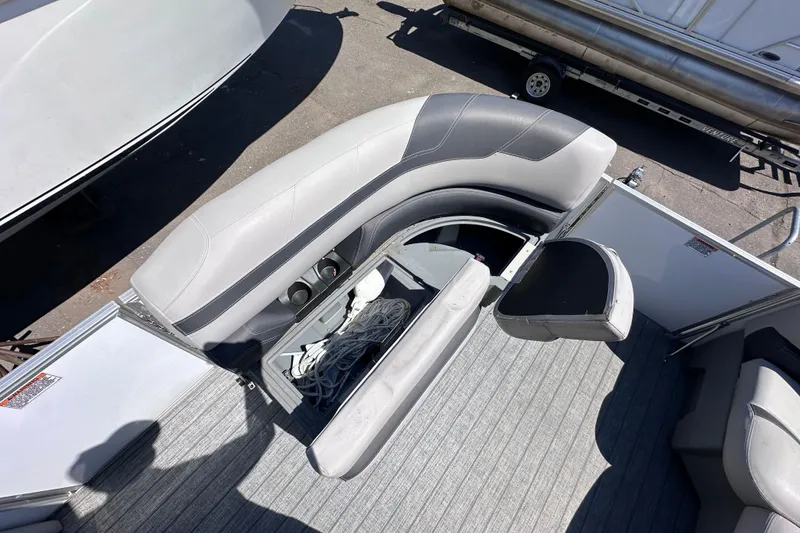 Slide: The Image of 2022 Sylvan L1 CRS boat interior with gray seating and storage compartment. - 15