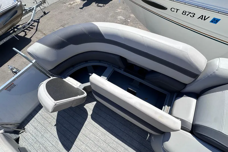 Slide: The Image of 2022 Sylvan L1 CRS boat interior with gray seating and storage compartment. - 16