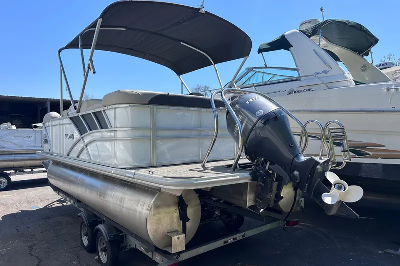Slide: The Image of 2022 Sylvan L1 CRS pontoon boat with Yamaha outboard motor on trailer. - 2