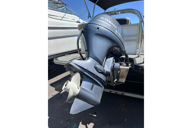 Slide: The Image of 2022 Sylvan L1 CRS with Yamaha outboard motor, docked beside another boat. - 20