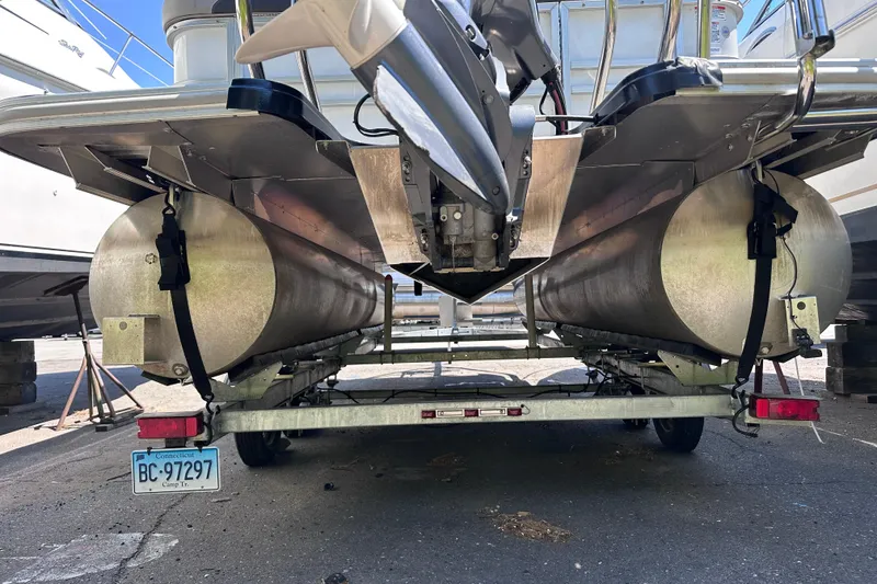 Slide: The Image of 2022 Sylvan L1 CRS pontoon boat on trailer, rear view showing pontoons and motor. - 4
