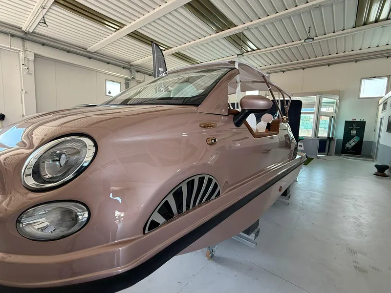 Slide: The Image of 2026 Fiat 500 Rose Gold boat in a showroom, showcasing unique design features. - 7