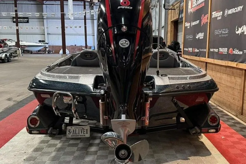 Slide: The Image of 2013 Ranger Z118 boat in showroom, rear view with motor and license plate. - 3