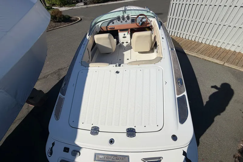 Slide: The Image of 2006 Chris-Craft Speedster boat with beige interior and wooden dashboard, parked outdoors. - 10