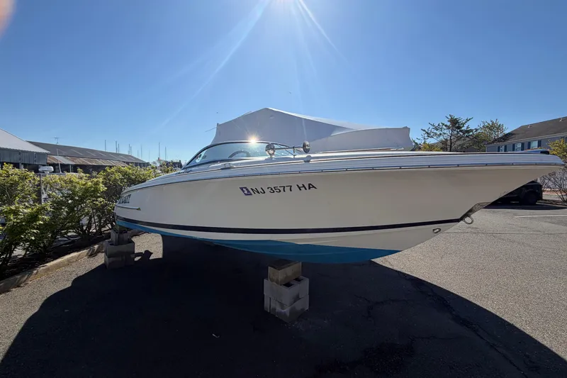 Slide: The Image of 2006 Chris-Craft Speedster boat on blocks, sunny day, marina background. - 2