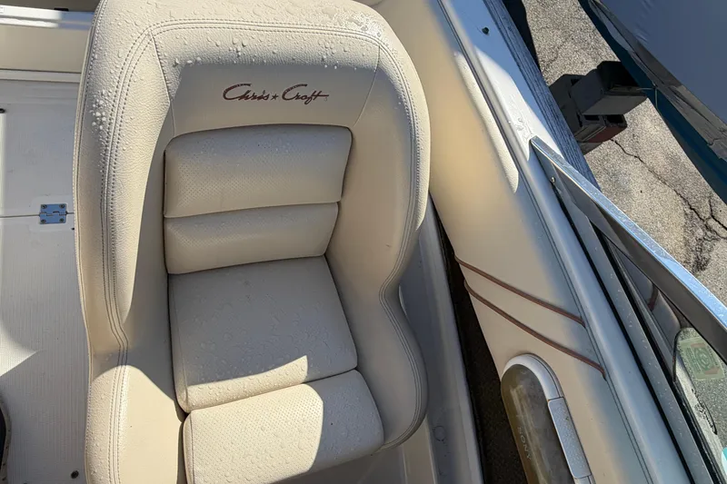 Slide: The Image of Cream leather seat in a 2006 Chris-Craft Speedster boat, with visible water droplets. - 22