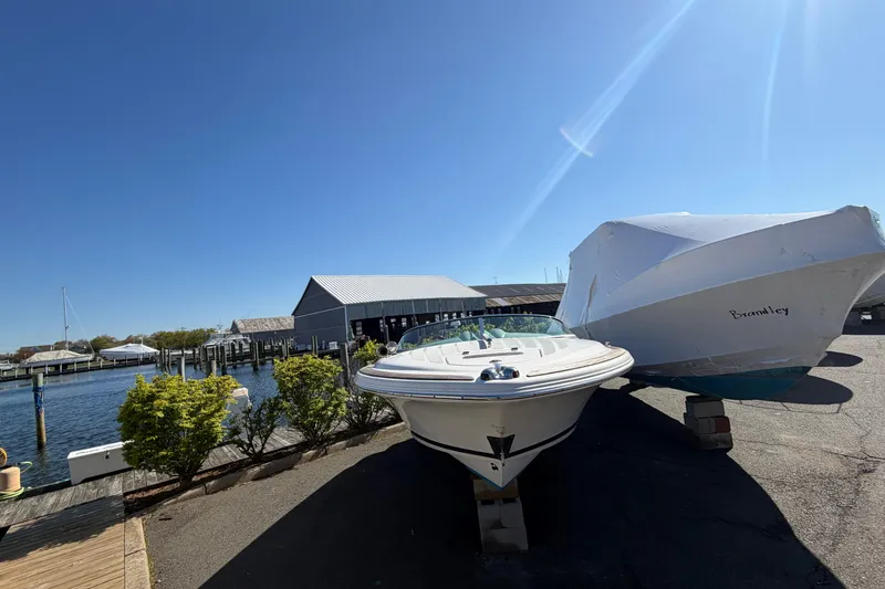 Slide: The Image of 2006 Chris-Craft Speedster boat docked near a marina under clear blue skies. - 4