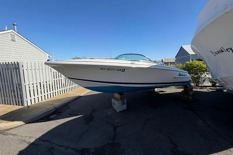 Slide: The Image of 2006 Chris-Craft Speedster boat on blocks, parked outdoors under clear blue sky. - 5