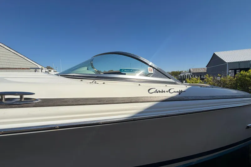 Slide: The Image of 2006 Chris-Craft Speedster boat with sleek design and classic logo under clear blue sky. - 6