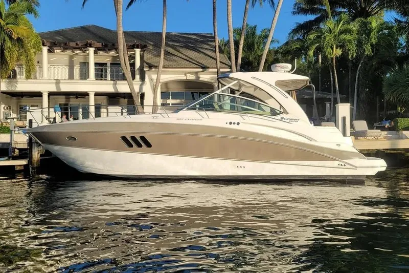 The Image of 2014 Cruisers Yachts 380 Express docked by a luxurious waterfront home. - 1